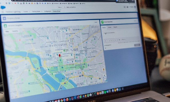 Laptop displaying a CRM screen with a map of Washington DC and a location pin dropped downtown