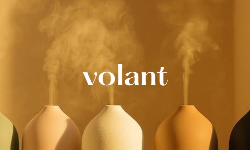 Ceramic aroma diffusers releasing steam against a warm gold backdrop with the Volant wordmark centred